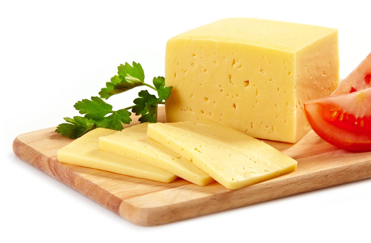 Cheese Slices with Tomato and Parsley on Wooden Board