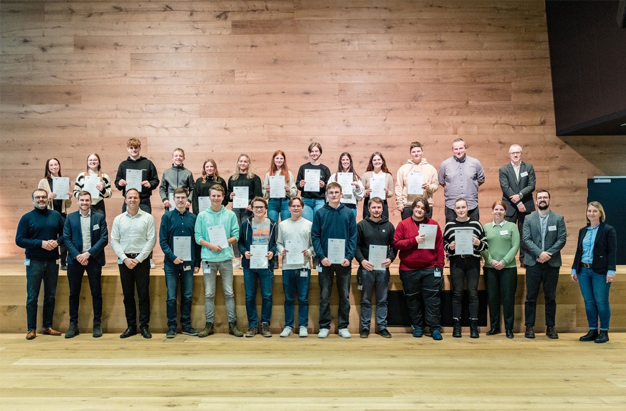 Group Photo with Certificates on Wooden Stage